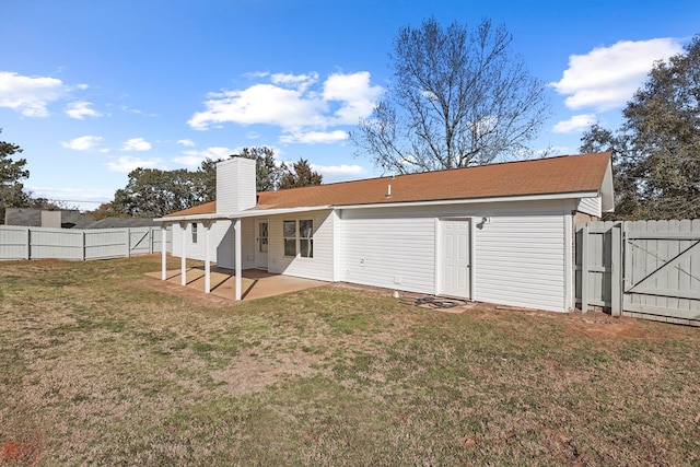 rear view of house with a patio and a lawn