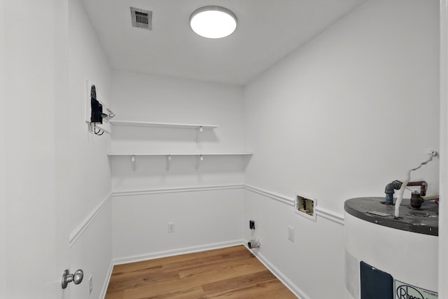 laundry room featuring hookup for a washing machine, hardwood / wood-style floors, and water heater