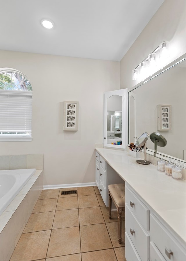 bathroom featuring tiled tub, tile patterned flooring, and vanity