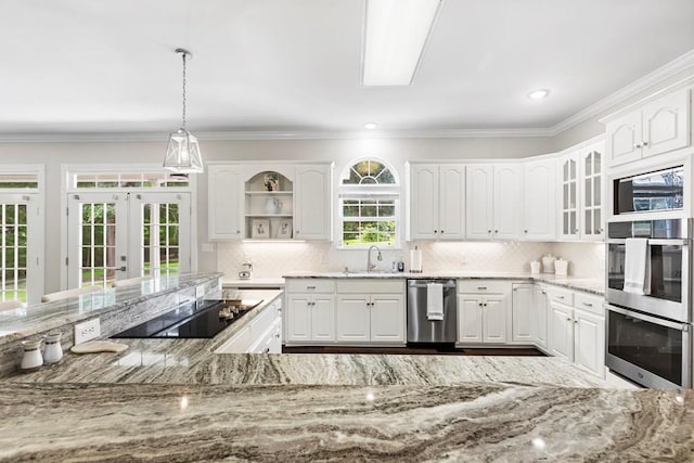 kitchen featuring white cabinets, appliances with stainless steel finishes, light stone countertops, and pendant lighting