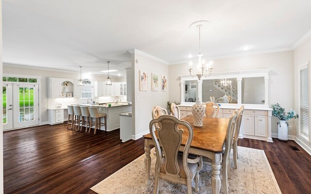 dining room with a notable chandelier, dark hardwood / wood-style flooring, and ornamental molding