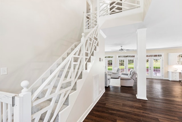 staircase featuring decorative columns, ceiling fan, french doors, and wood-type flooring