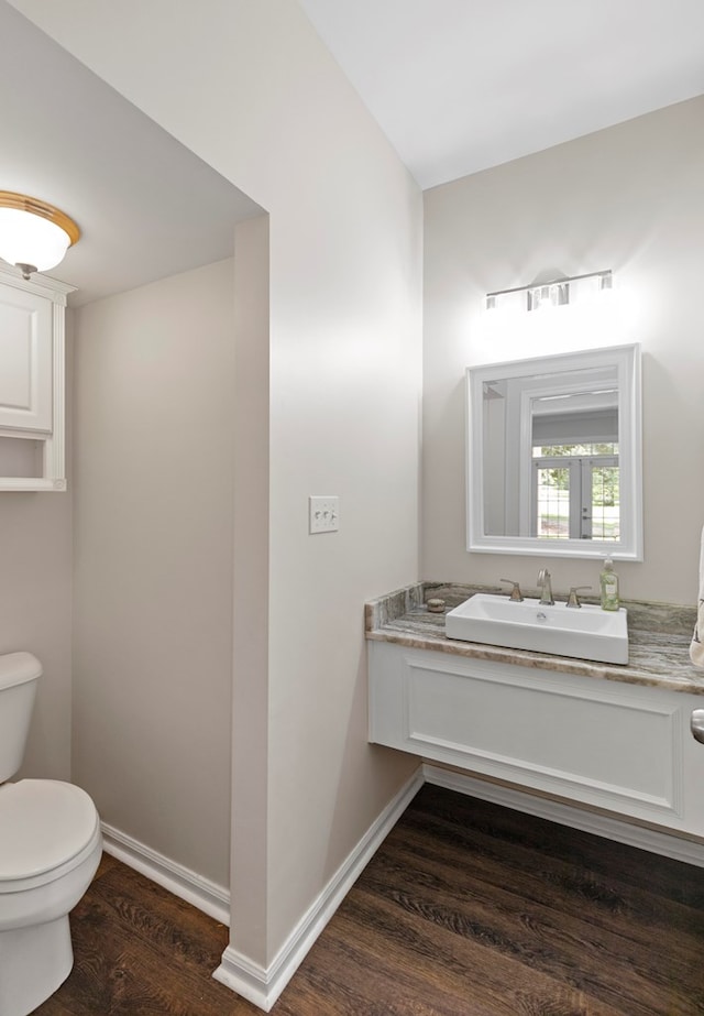 bathroom with toilet, vanity, and hardwood / wood-style flooring