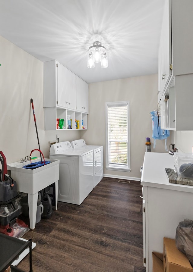 laundry room with cabinets, dark hardwood / wood-style flooring, and washing machine and clothes dryer