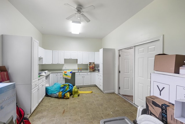 kitchen featuring ceiling fan and white cabinets