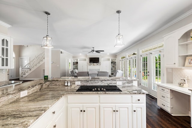 kitchen with black electric stovetop, ceiling fan, dark wood-type flooring, white cabinetry, and hanging light fixtures