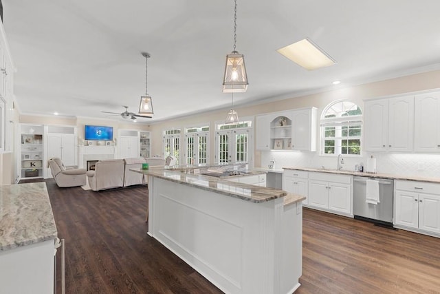 kitchen with light stone counters, hanging light fixtures, white cabinets, and stainless steel dishwasher