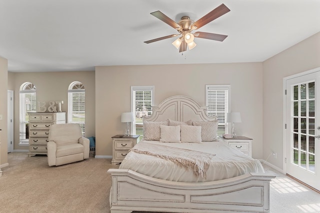 bedroom featuring access to exterior, ceiling fan, light colored carpet, and multiple windows