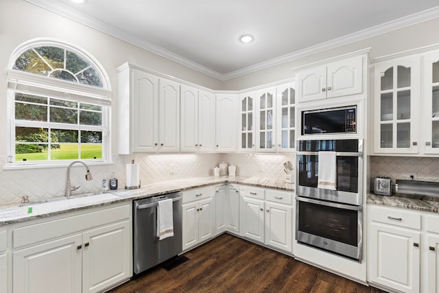 kitchen featuring light stone countertops, stainless steel appliances, and white cabinetry