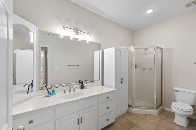 bathroom featuring tile patterned floors, vanity, toilet, and a shower with shower door