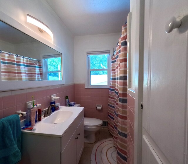 bathroom with tile patterned floors, toilet, vanity, and tile walls