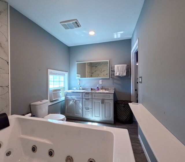 bathroom featuring wood-type flooring, a tub, cooling unit, and vanity