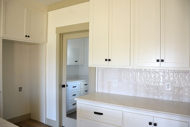 kitchen featuring custom exhaust hood and white cabinetry