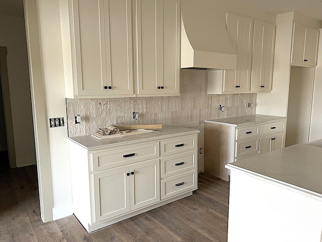 kitchen with light wood finished floors, white cabinetry, tasteful backsplash, and wall chimney exhaust hood