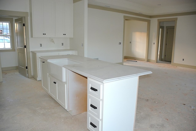 kitchen featuring sink, a center island, and white cabinetry