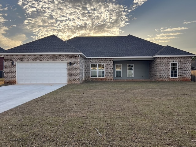 ranch-style home with brick siding, a shingled roof, and a garage