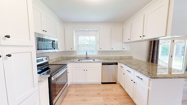1007 Deborah St, Dothan, AL 36301 - kitchen featuring stainless steel appliances, a peninsula, light wood-type flooring, and white cabinetry