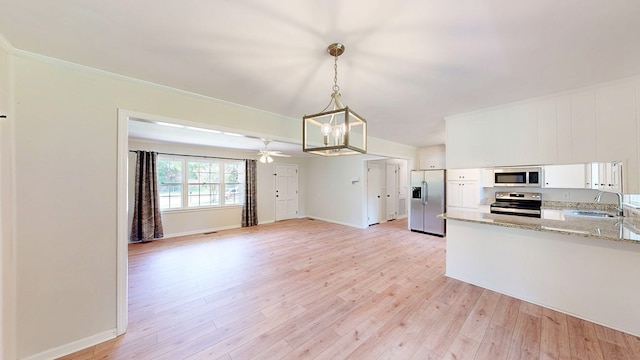 1007 Deborah St, Dothan, AL 36301 - kitchen featuring appliances with stainless steel finishes, white cabinetry, light wood-style floors, light stone countertops, and a chandelier