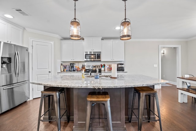 2027 S County Road 9, Newton, AL 36352 - kitchen featuring appliances with stainless steel finishes, ornamental molding, dark wood-style flooring, white cabinets, and a breakfast bar