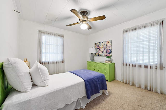 carpeted bedroom featuring ceiling fan and ornamental molding