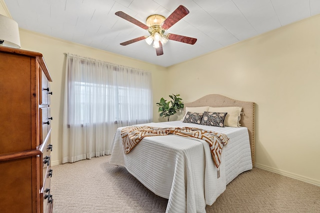 bedroom with ceiling fan, crown molding, and light colored carpet