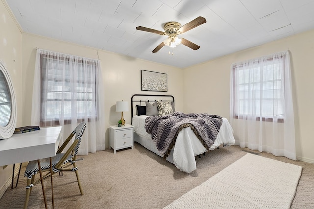 bedroom with ceiling fan, crown molding, and light carpet