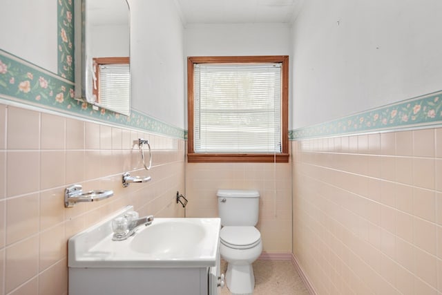 bathroom with vanity, toilet, tile walls, and ornamental molding