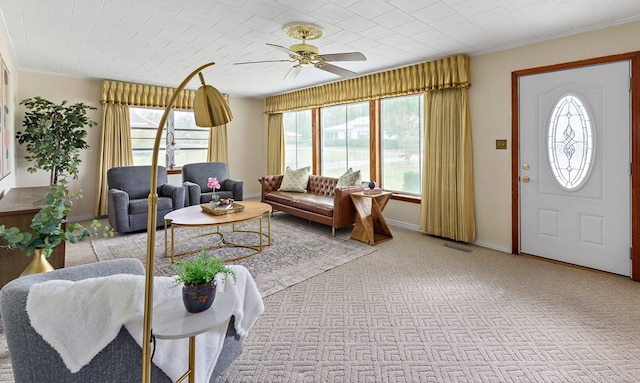 carpeted living room with ceiling fan and ornamental molding