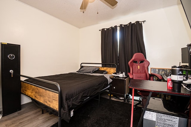 bedroom with a ceiling fan, wood finished floors, and a textured ceiling