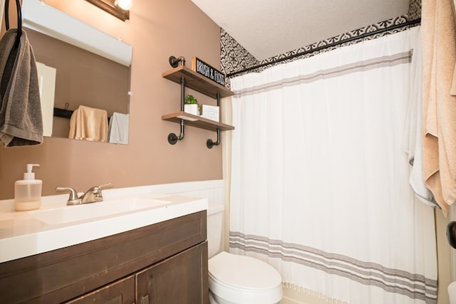 bathroom with a shower with curtain, vanity, and toilet