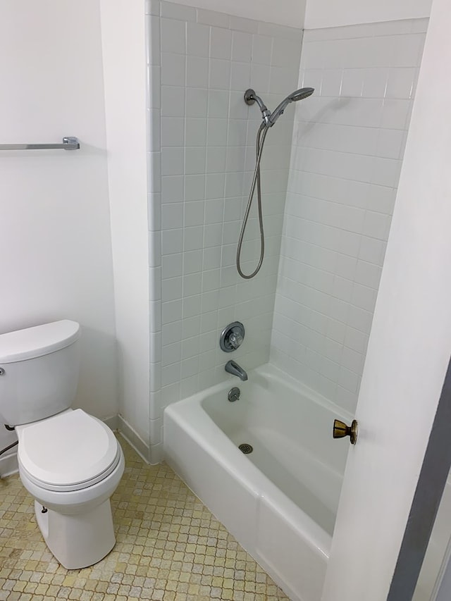 bathroom with tiled shower / bath and toilet