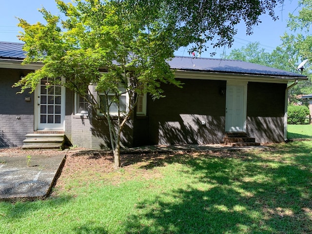 view of side of home with a yard