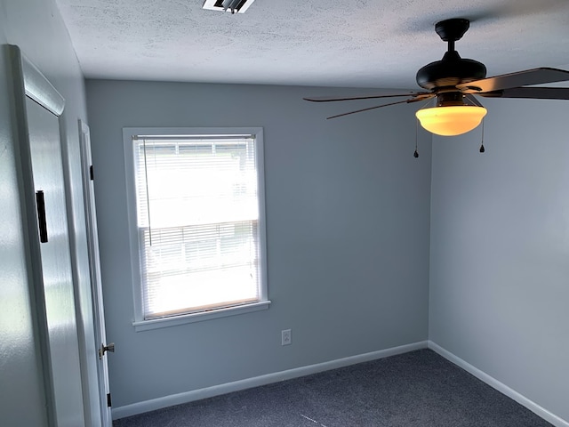 carpeted spare room with ceiling fan and a textured ceiling