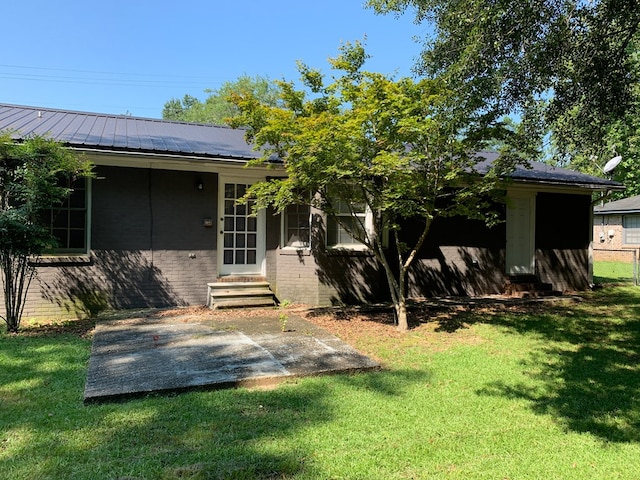 rear view of property featuring a yard