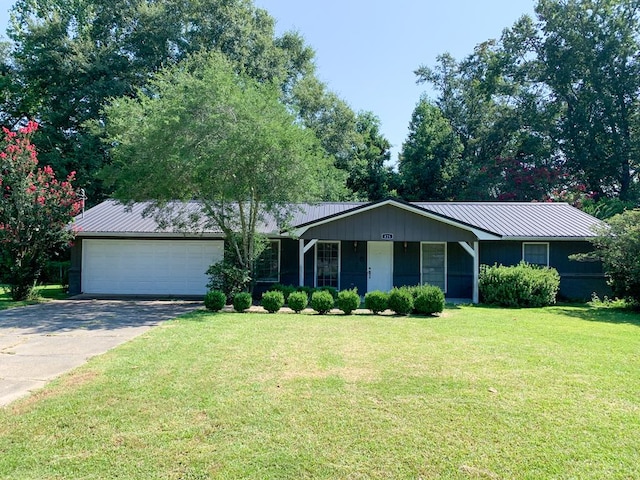 ranch-style home with a garage and a front lawn