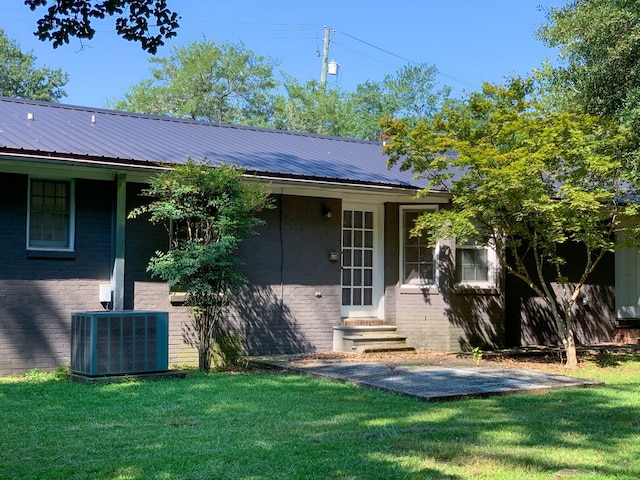 exterior space featuring central AC unit and a lawn