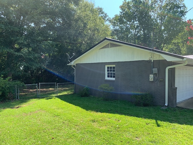 view of side of home featuring a garage and a lawn