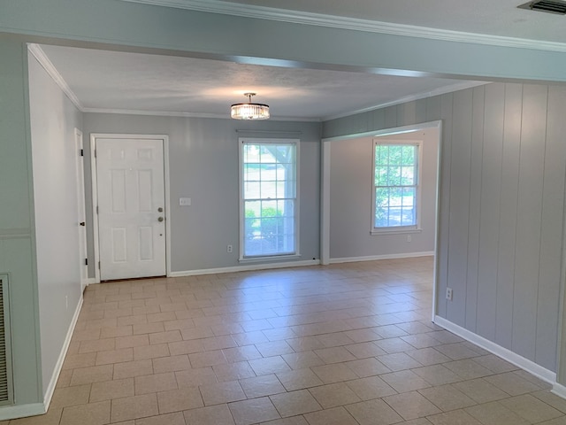 spare room featuring light tile patterned floors, ornamental molding, and a notable chandelier