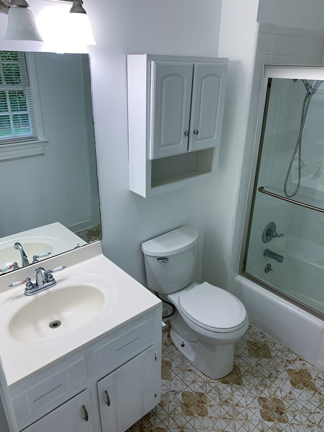 full bathroom with tile patterned floors, vanity, enclosed tub / shower combo, and toilet