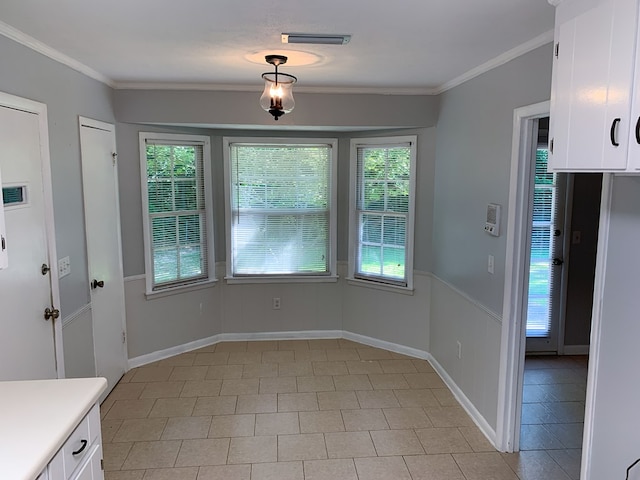 unfurnished dining area featuring a healthy amount of sunlight, ornamental molding, and light tile patterned floors