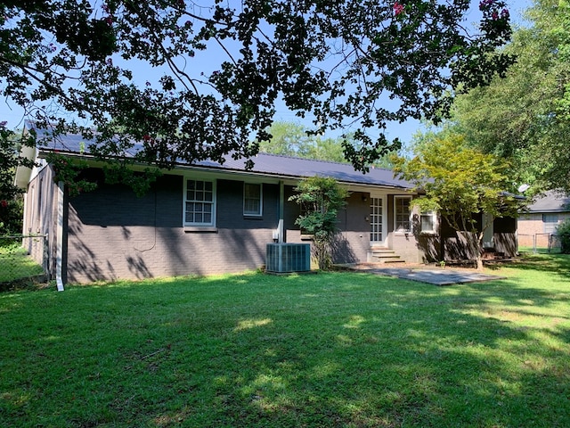 back of property with a lawn and central air condition unit