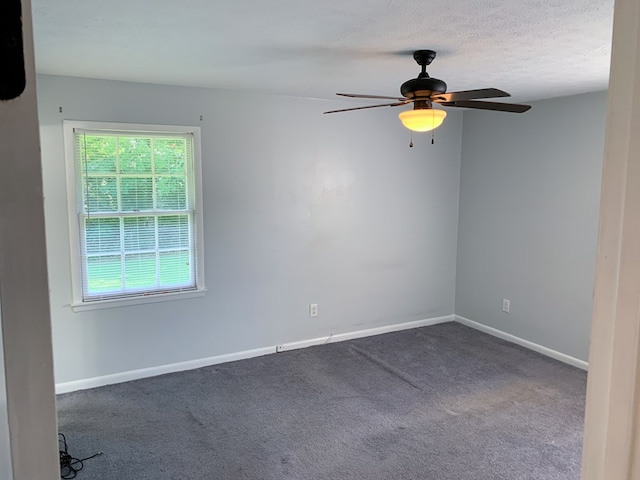 empty room with carpet flooring, ceiling fan, and a textured ceiling