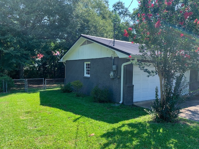 view of side of home with a yard and a garage