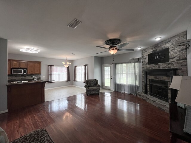 305 Millenia St, Enterprise, AL 36330 - living area featuring a stone fireplace, plenty of natural light, a ceiling fan, and wood finished floors