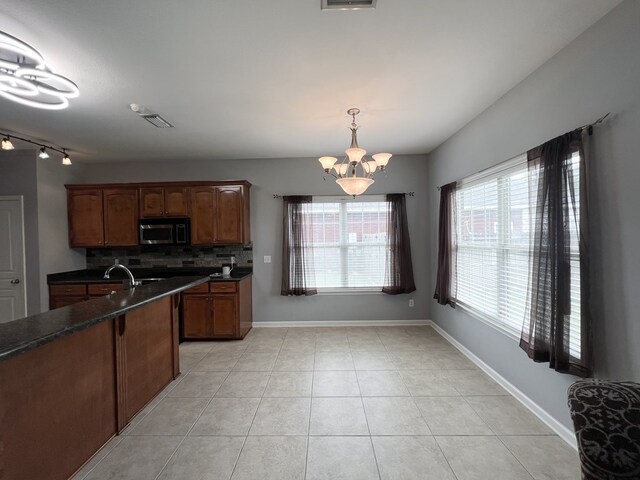 305 Millenia St, Enterprise, AL 36330 - kitchen featuring stainless steel microwave, tasteful backsplash, dark countertops, and a chandelier