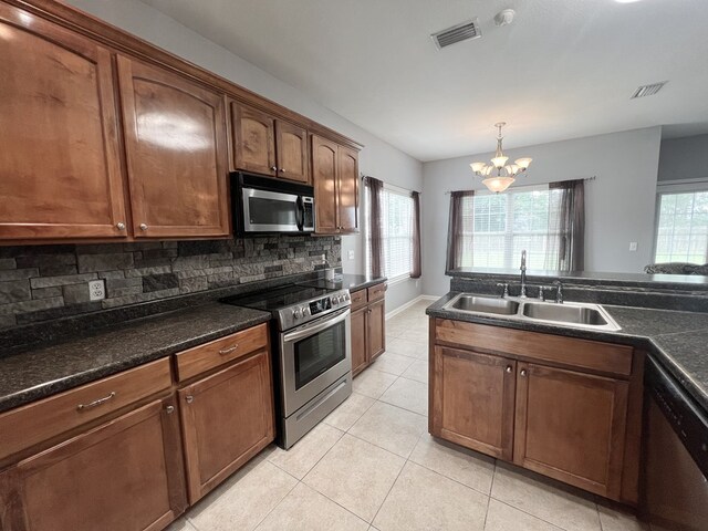 305 Millenia St, Enterprise, AL 36330 - kitchen featuring appliances with stainless steel finishes, a sink, a chandelier, decorative backsplash, and light tile patterned flooring