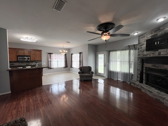 305 Millenia St, Enterprise, AL 36330 - living area featuring a ceiling fan, wood finished floors, a stone fireplace, a chandelier, and baseboards