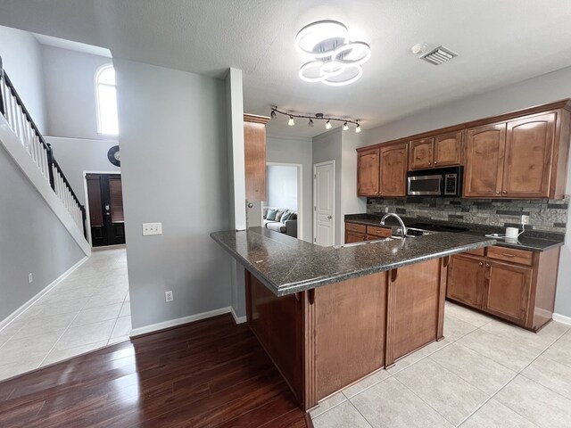 305 Millenia St, Enterprise, AL 36330 - kitchen with stainless steel microwave, dark countertops, backsplash, a sink, and baseboards