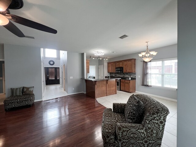 305 Millenia St, Enterprise, AL 36330 - living area with a chandelier, a ceiling fan, baseboards, and light wood-style floors