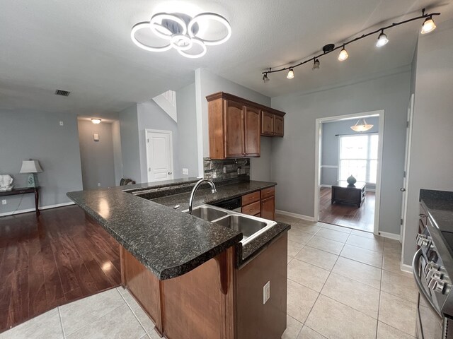305 Millenia St, Enterprise, AL 36330 - kitchen featuring stove, light tile patterned floors, a sink, and a peninsula